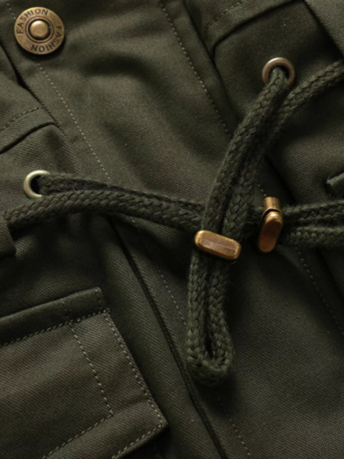 Close-up of the Army Green jacket waist drawcord, eyelets, cord ends and snap fastener.