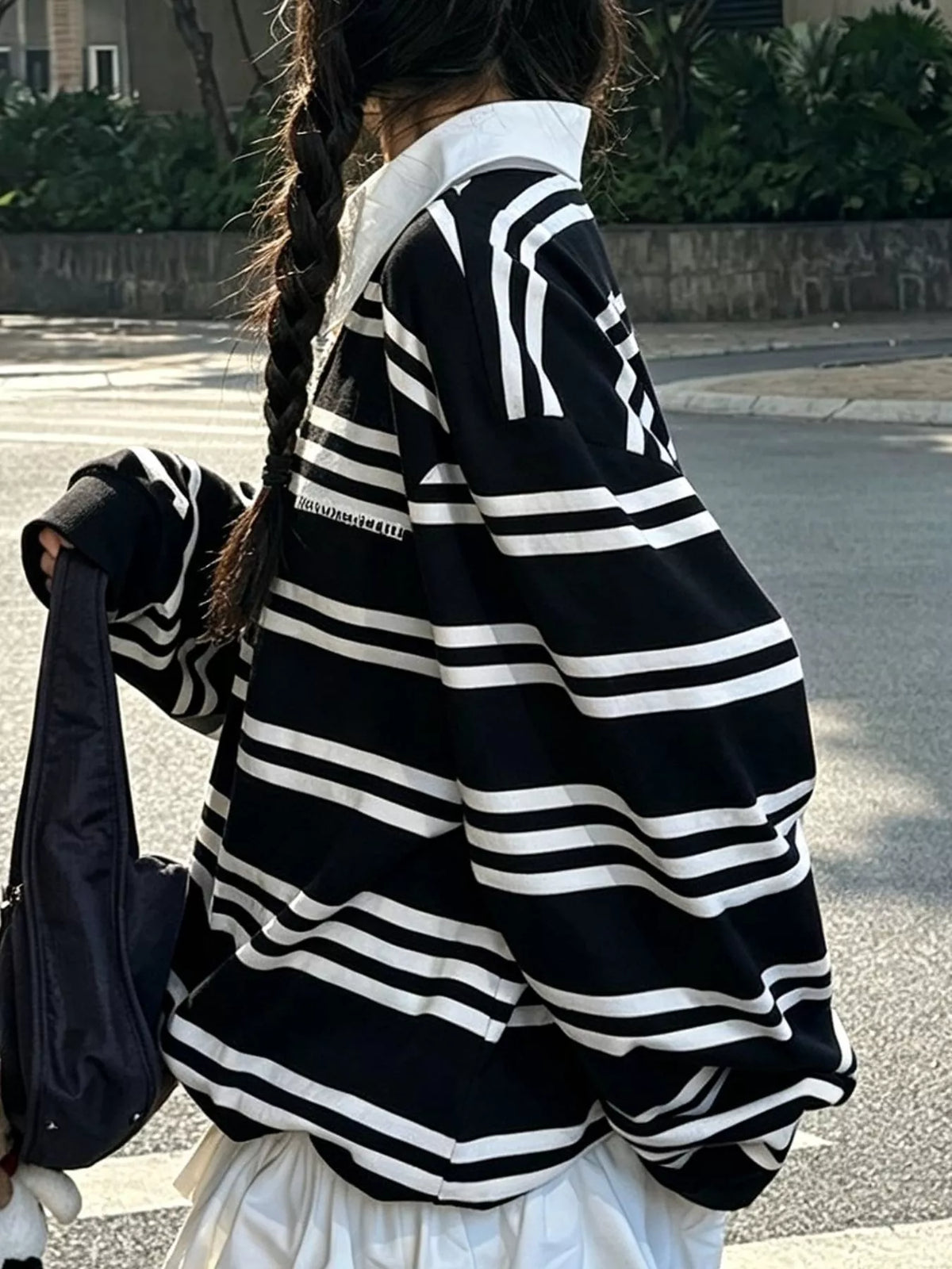 Black and white striped polo, side view showing long sleeves and contrast collar