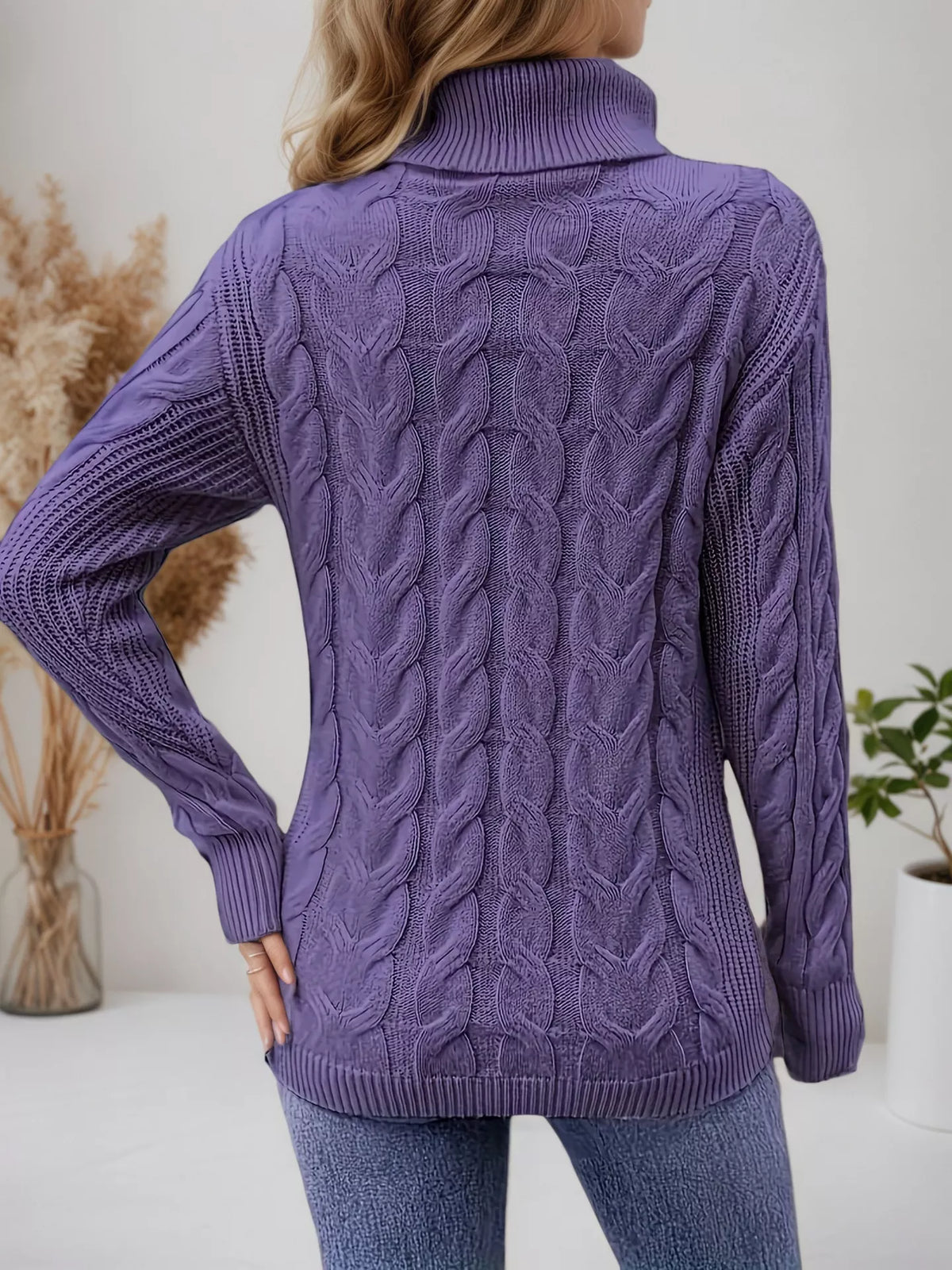 Cable-knit turtleneck sweater with long sleeves.