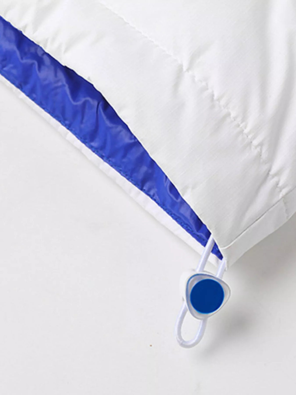 White jacket adjustable drawstring hem with blue toggle and contrast lining, close-up