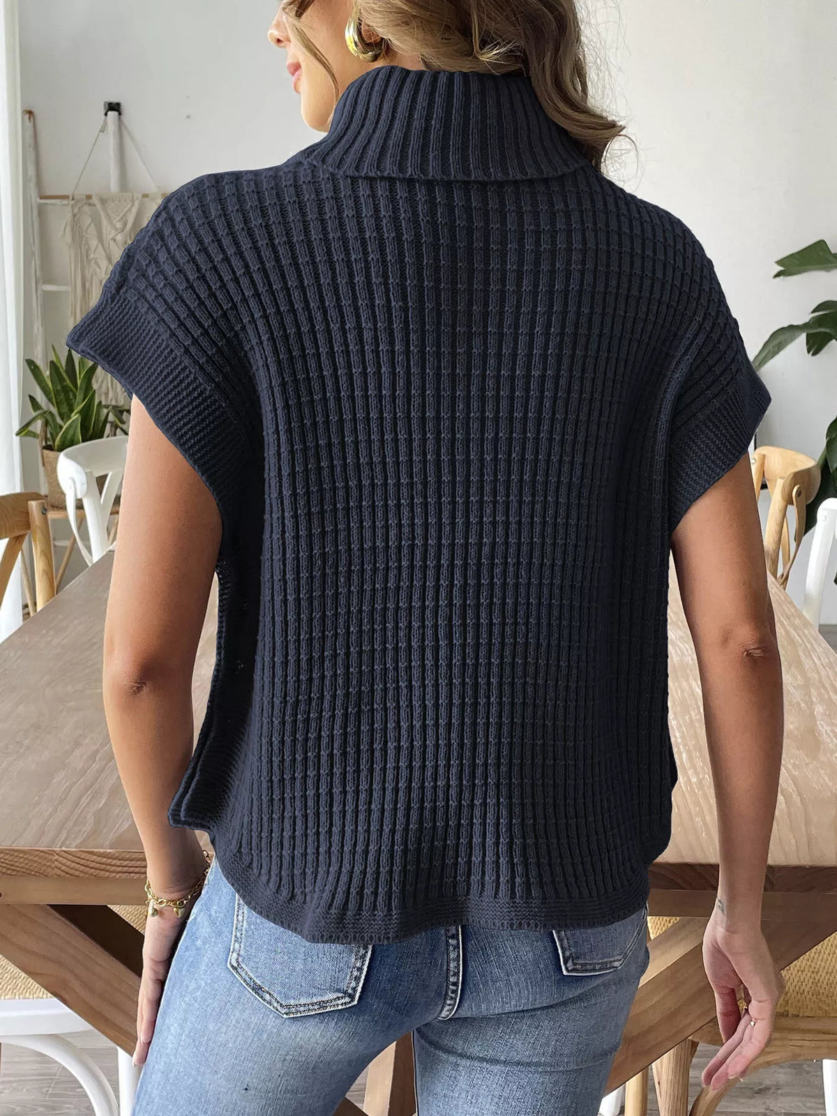 Back view of the Navy Blue ribbed turtleneck sweater vest; jeans are styling only.