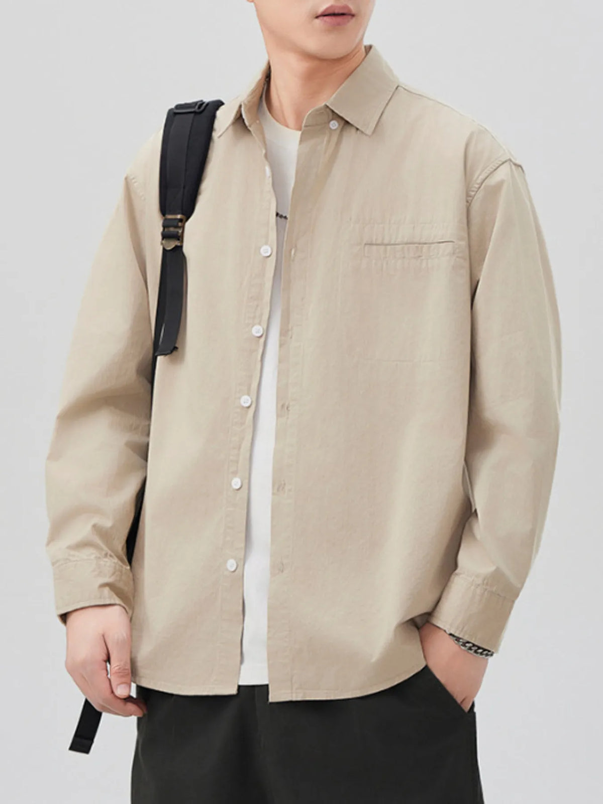 Khaki long-sleeve shirt open over a white T-shirt, front view with bag strap