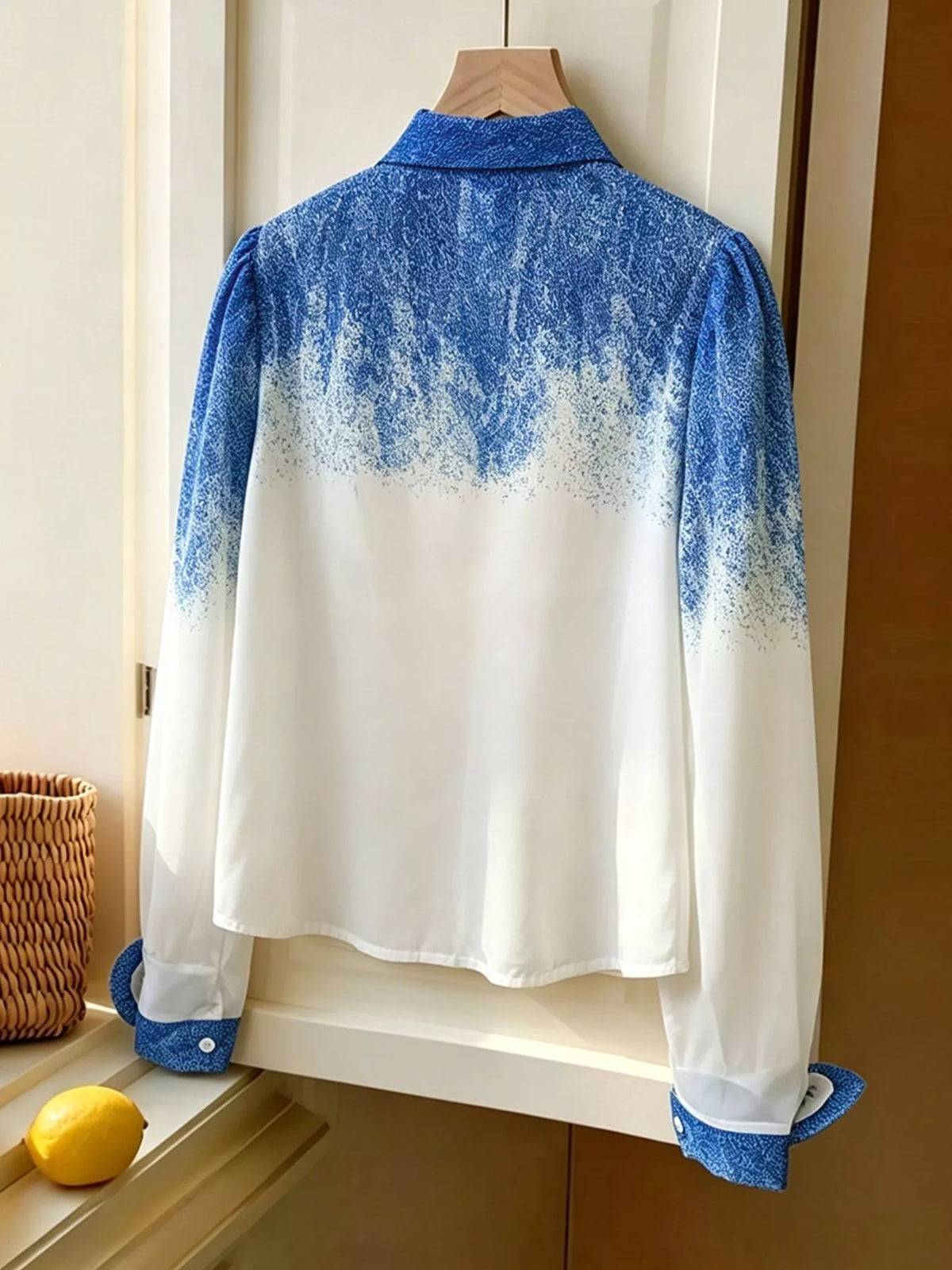 Blue-to-white gradient long-sleeve shirt on a hanger, back view