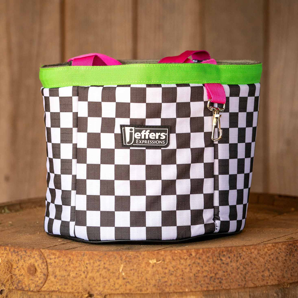 Skater Cowgirl checkerboard grooming tote shown on a wooden surface, with neon-green trim and hot-pink handles.