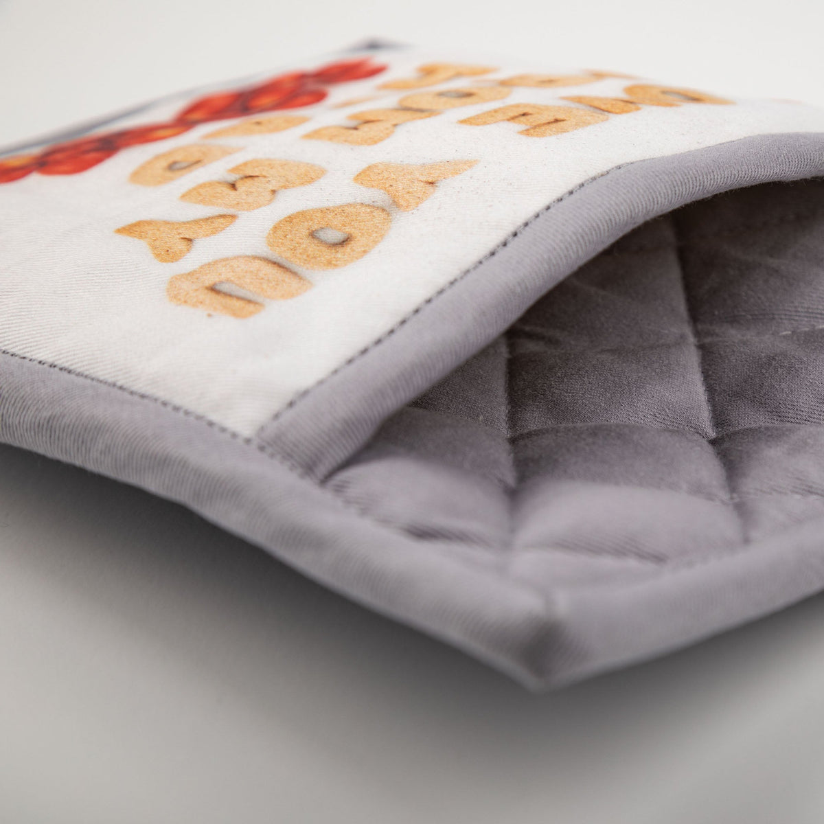 Close-up of the Tomatoes pot-holder trim and padded construction.