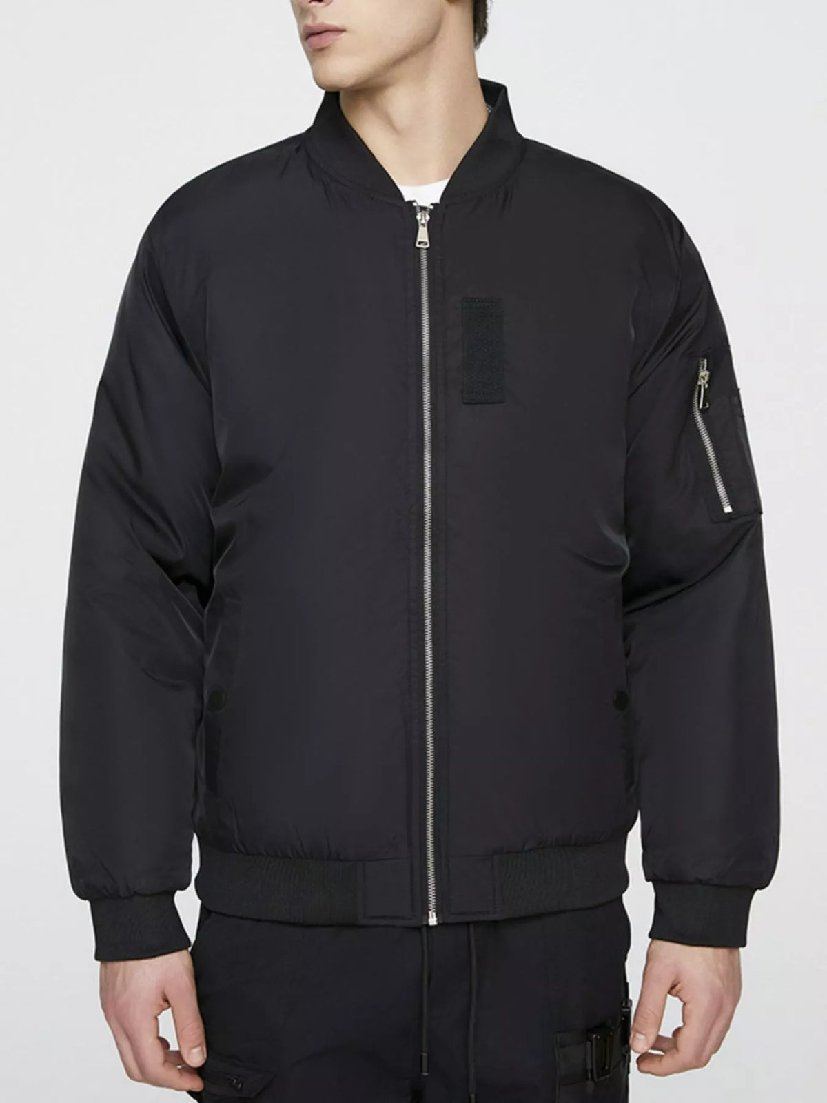 Black bomber jacket shown zipped from the front, with ribbed collar, cuffs and hem; trousers are not included.