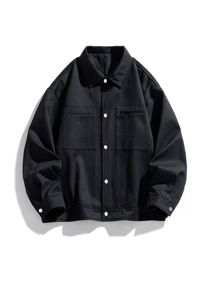Black snap-front jacket shown on its own from the front, with two chest patch pockets.