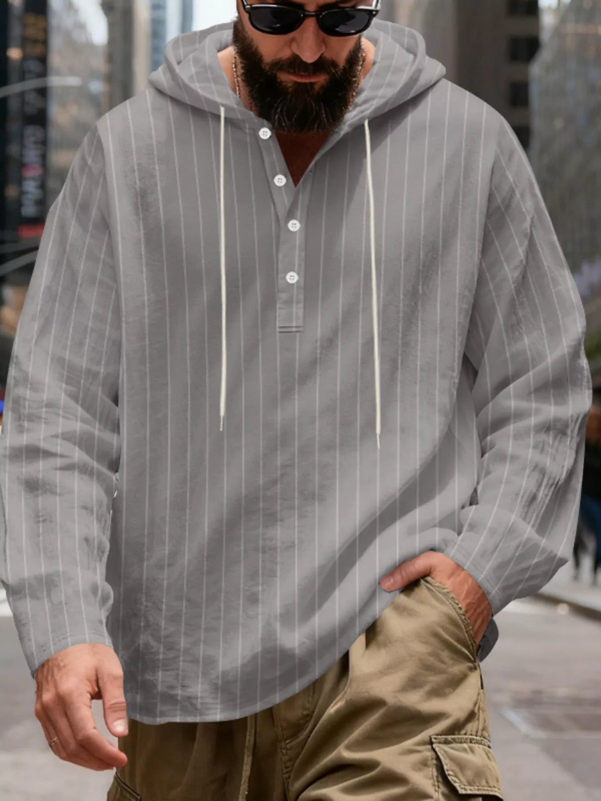 Men's striped Henley hoodie in Gray — front view showing the hood and buttoned neckline; trousers and accessories are styling only.