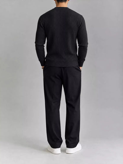 Black ribbed knit top, modelled rear view. Trousers and shoes are not included.