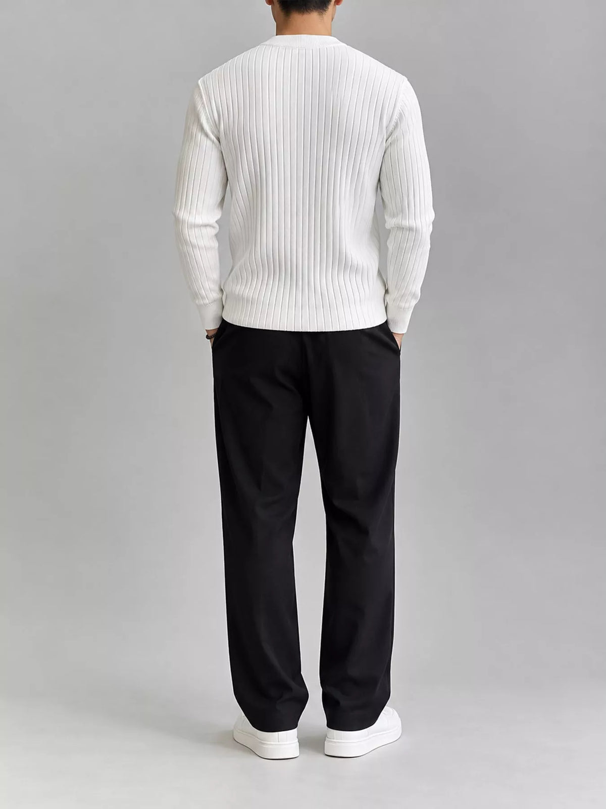 White ribbed knit top, modelled rear view. Trousers and shoes are not included.