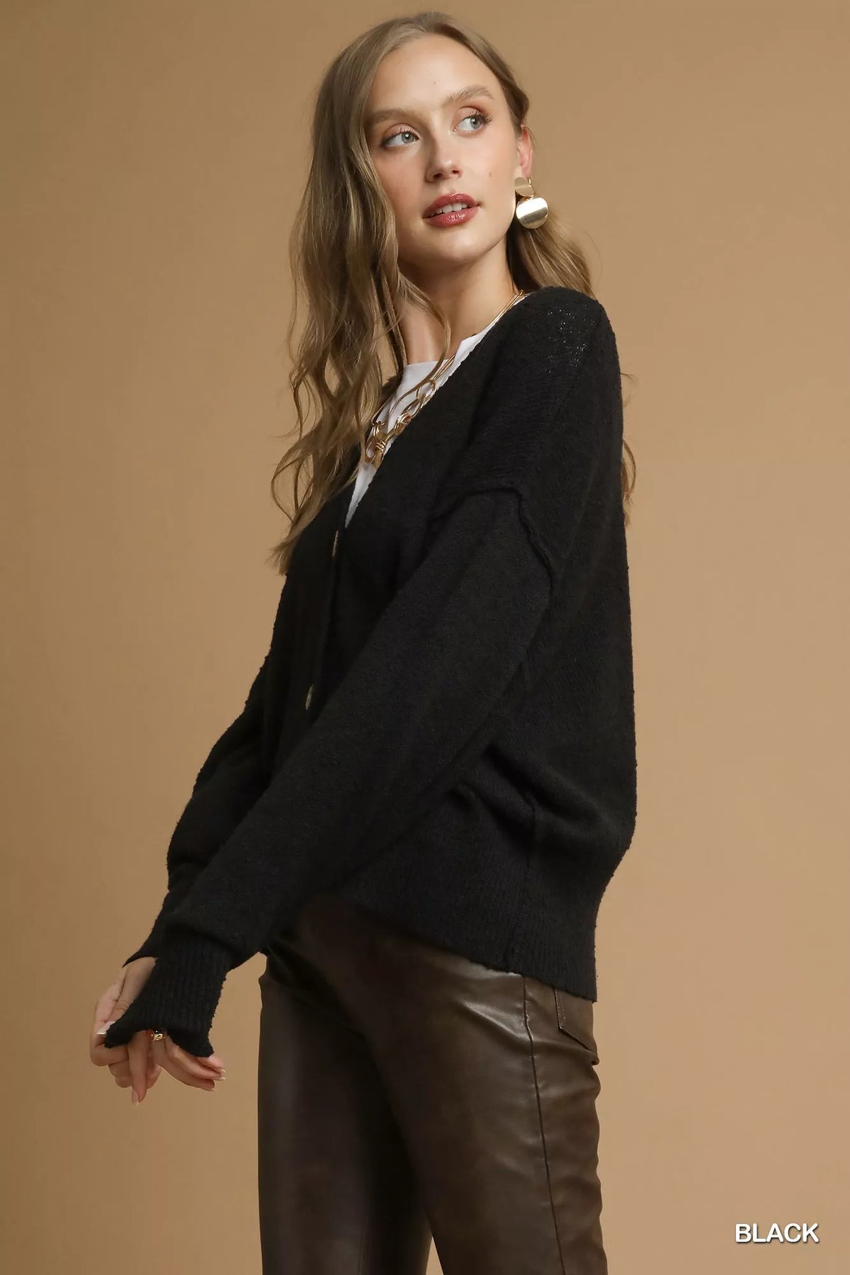 Side view of the Umgee black knit cardigan showing the sleeve and relaxed shape