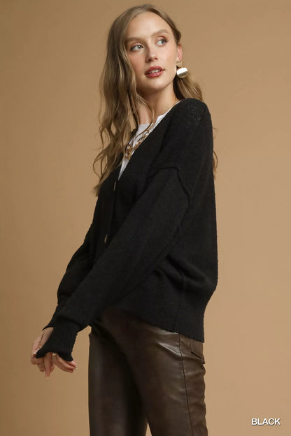 Side view of the Umgee black knit cardigan showing the sleeve and relaxed shape