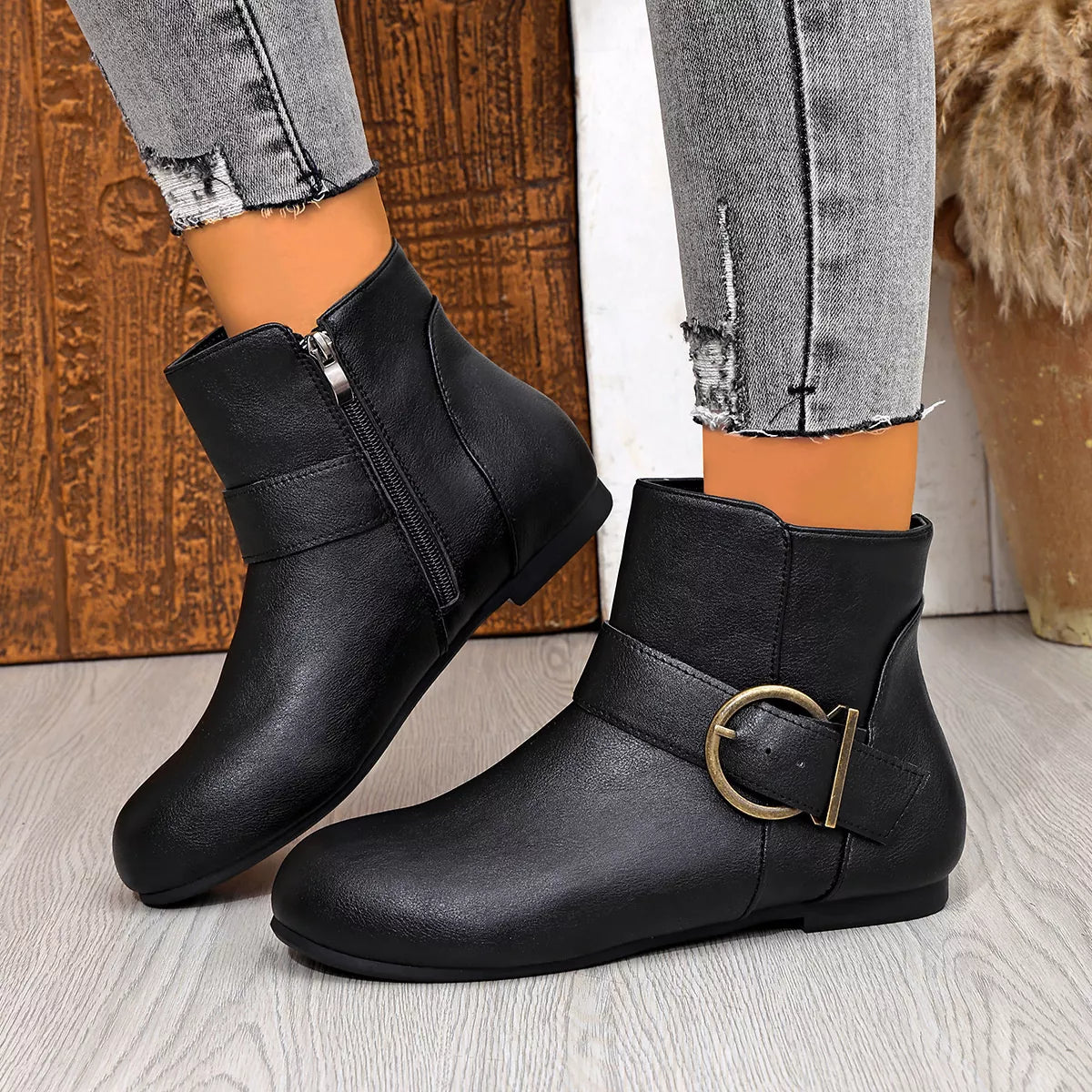 Black ankle boots showing side zippers and buckle detail