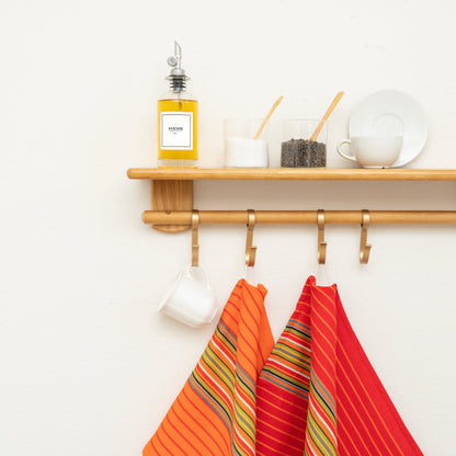 Red & Orange Salsa Stripe kitchen towels hanging in a kitchen