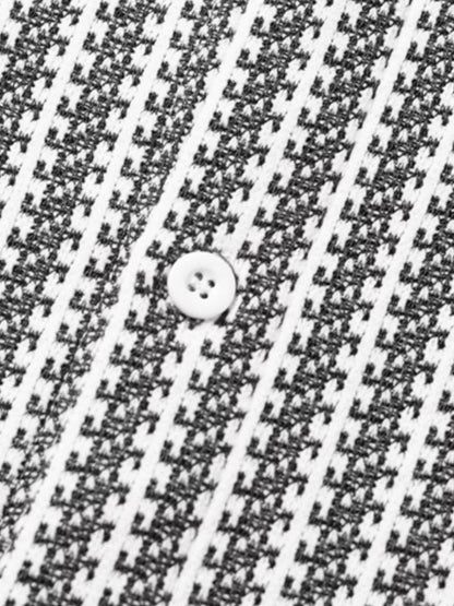Close-up of the White-patterned shacket fabric and a front button.