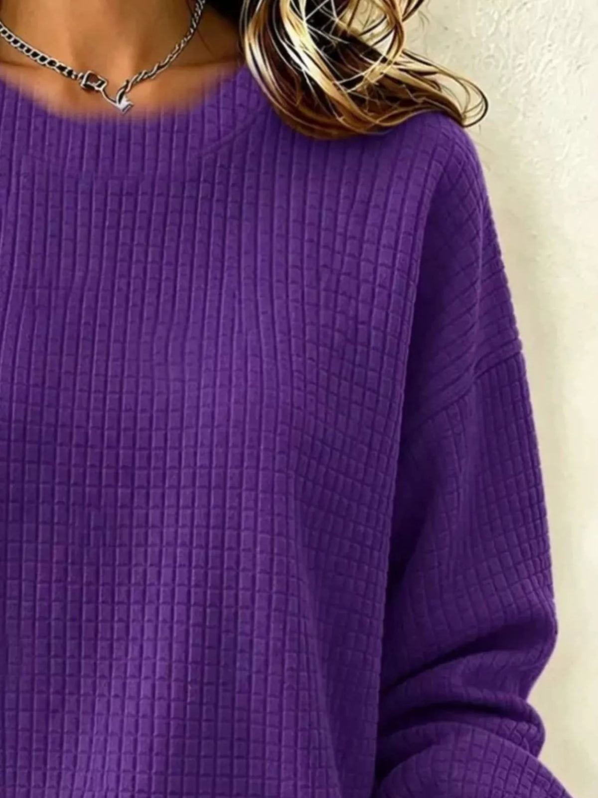 Close-up of the Purple sweatshirt's crew neckline, waffle-knit texture and sleeve.