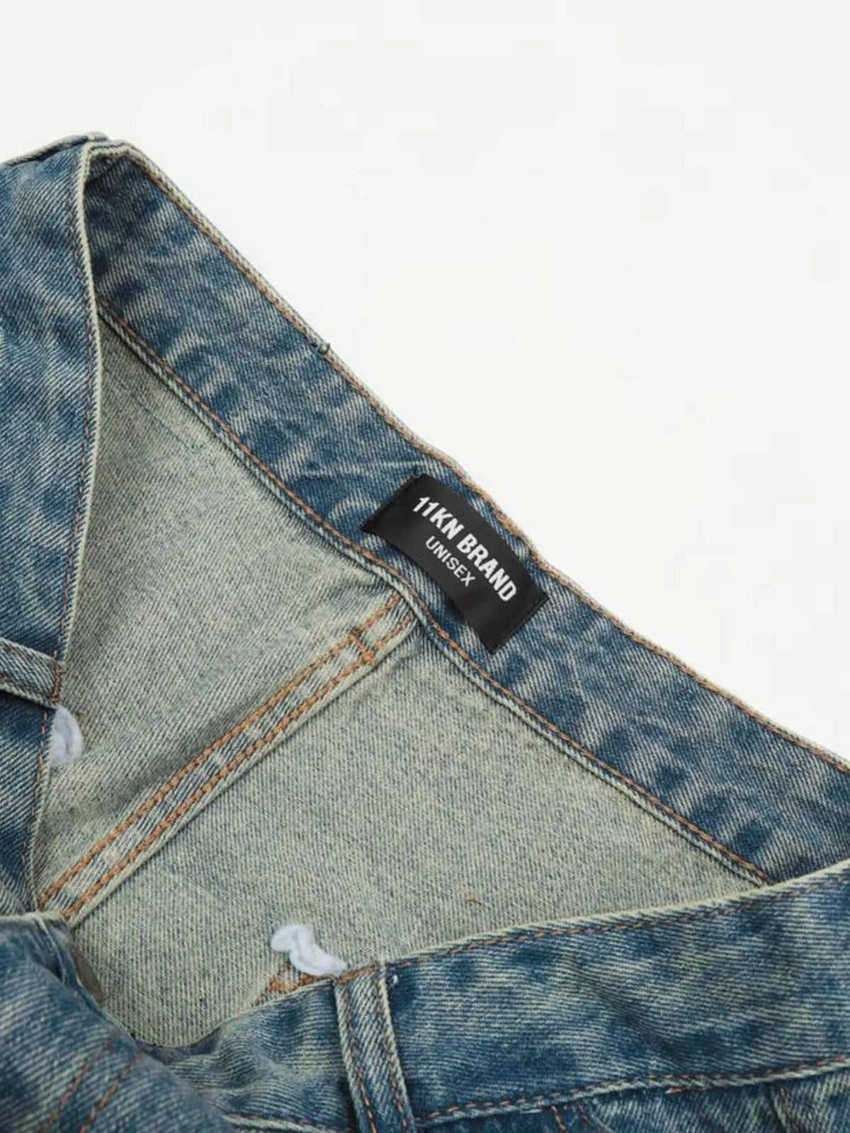 Interior waistband view of the blue cargo jeans, showing the sewn-in label and denim reverse.