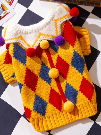 Yellow diamond-pattern pet sweater with colorful pom-pom details, shown flat.