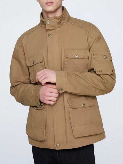 Khaki multi-pocket men's jacket shown fastened from the front with the model adjusting a cuff; trousers are not included.