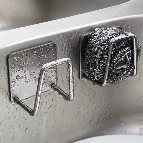 Two stainless steel sink-side sponge holders shown mounted by a sink; pictured scrubber and sink are not included.