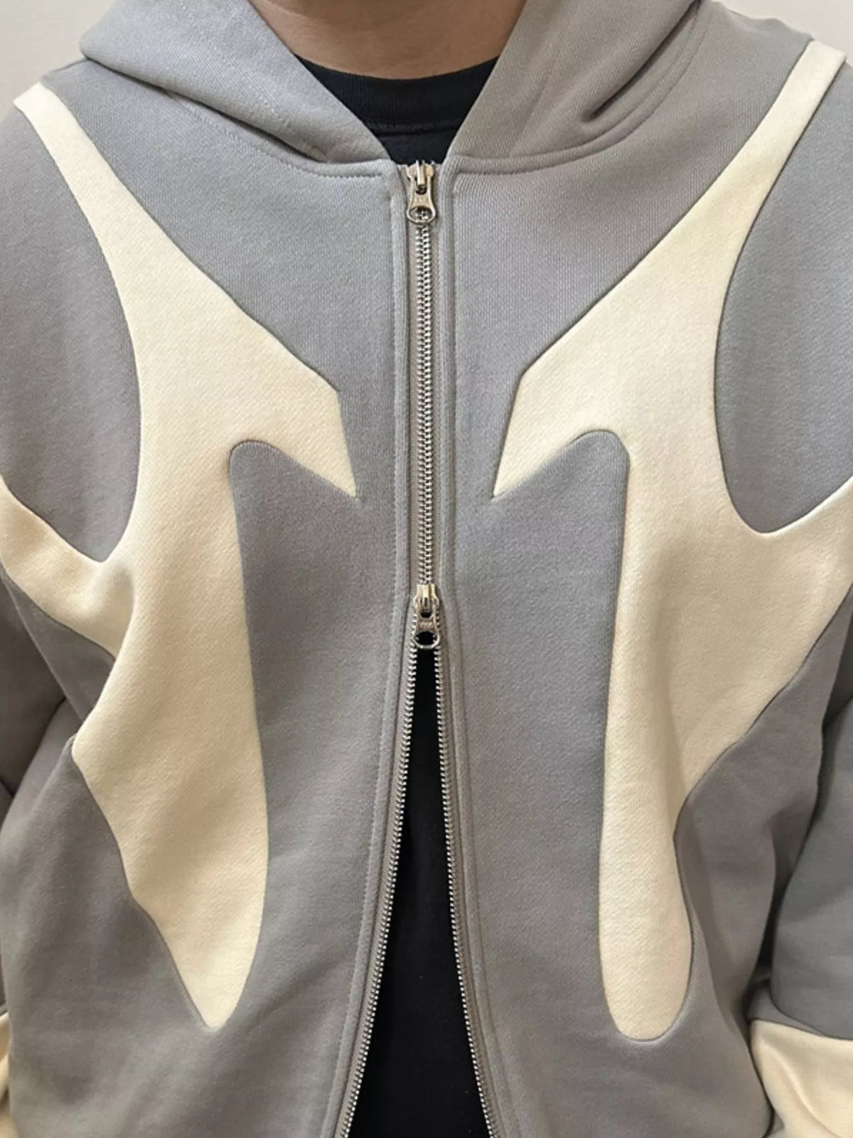 Gray and cream hoodie front zipper and contrast-panel detail