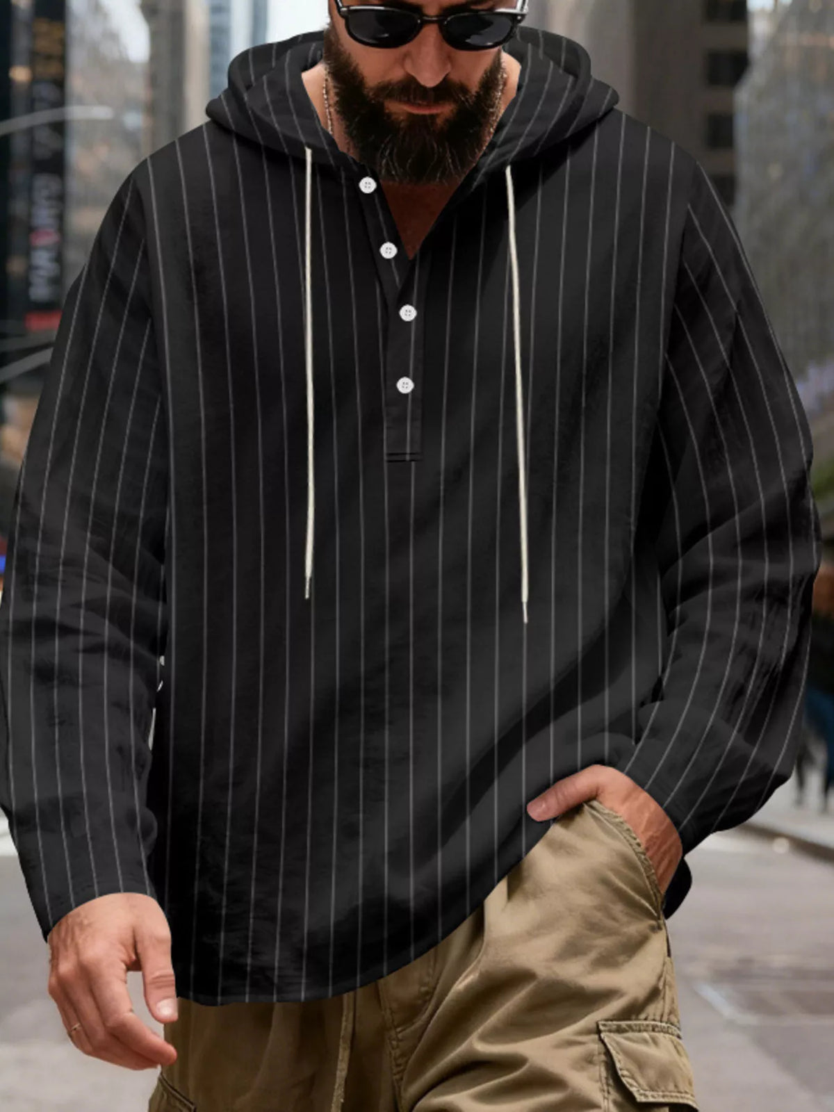 Men's striped Henley hoodie in Black — front view showing the hood and buttoned neckline; trousers and accessories are styling only.