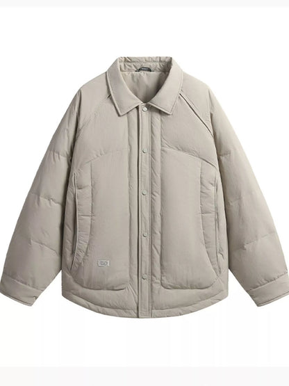 Light taupe padded jacket front showing a point collar, snap placket, large lower pockets and curved hem.
