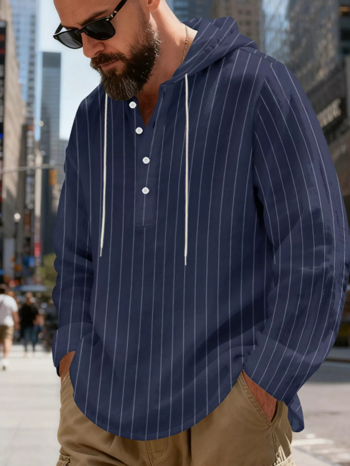 Men's striped Henley hoodie in Navy Blue — angled front view showing the hood and buttoned neckline; trousers and accessories are styling only.