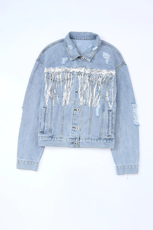 Blue denim jacket laid flat, buttoned front view with pointed collar, pockets, distressed patches and silver sequin fringe.