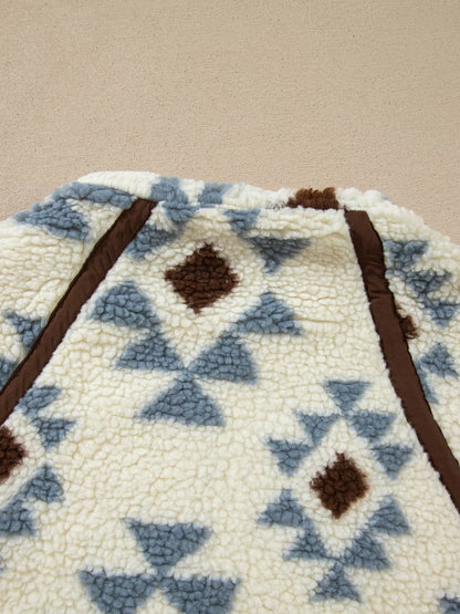 Close-up of geometric motifs and brown seam trim on the sweatshirt.