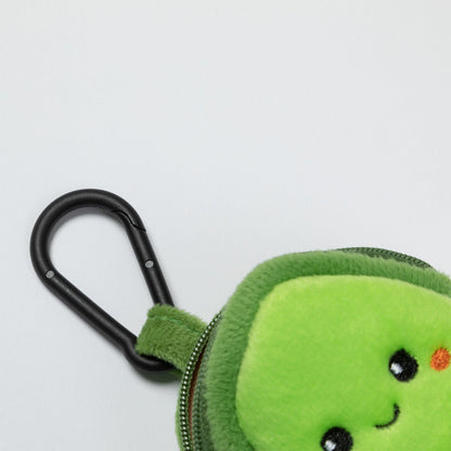 Close-up of the avocado dispenser's black clip, green fabric loop and plush front.
