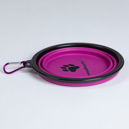 Pink pet bowl folded flat, with black rim, matching carabiner and printed paw design.
