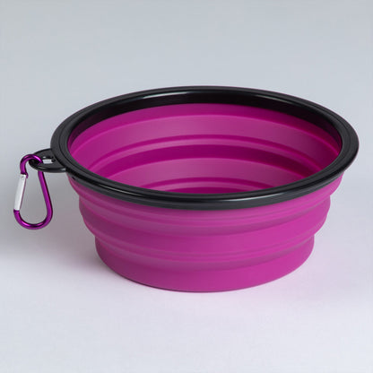 Pink collapsible silicone pet bowl opened, with a black rim and matching carabiner.
