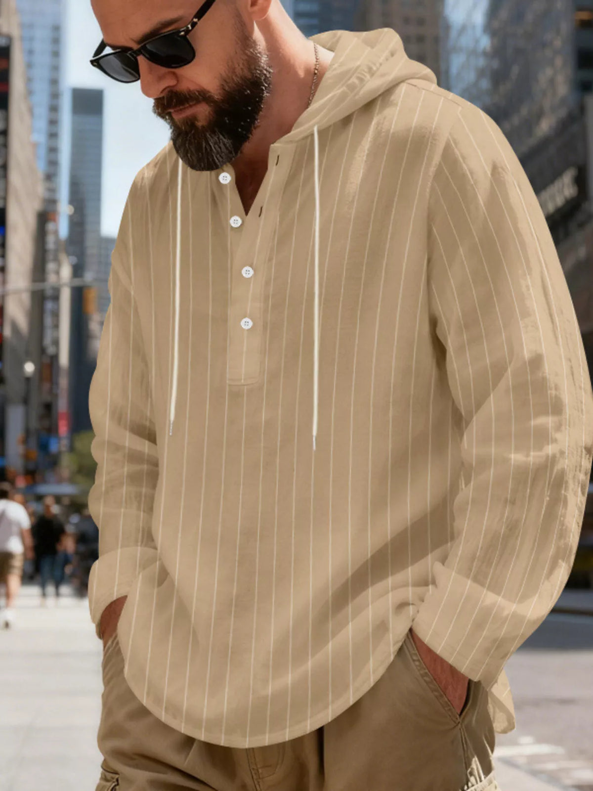 Men's striped Henley hoodie in Khaki — angled front view showing the hood and buttoned neckline; trousers and accessories are styling only.