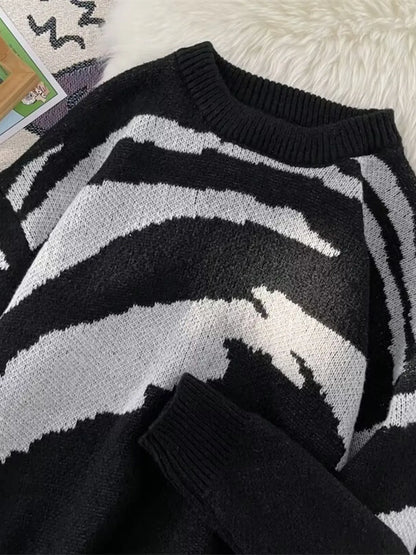 Close-up of the sweater's ribbed round neckline and sleeve cuff, showing the contrasting knit pattern.