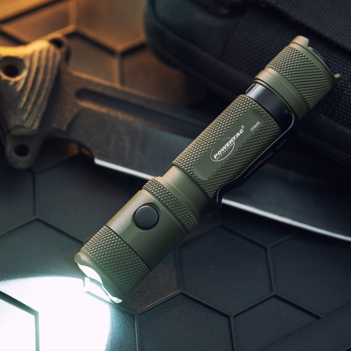 OD Green Powertac M5 Gen3 flashlight illuminated in a dark setting