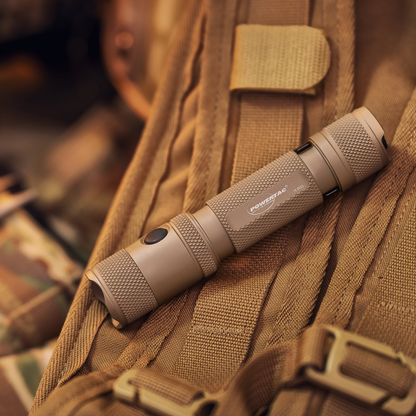 Flat Dark Earth Powertac M5 Gen3 flashlight resting on outdoor gear