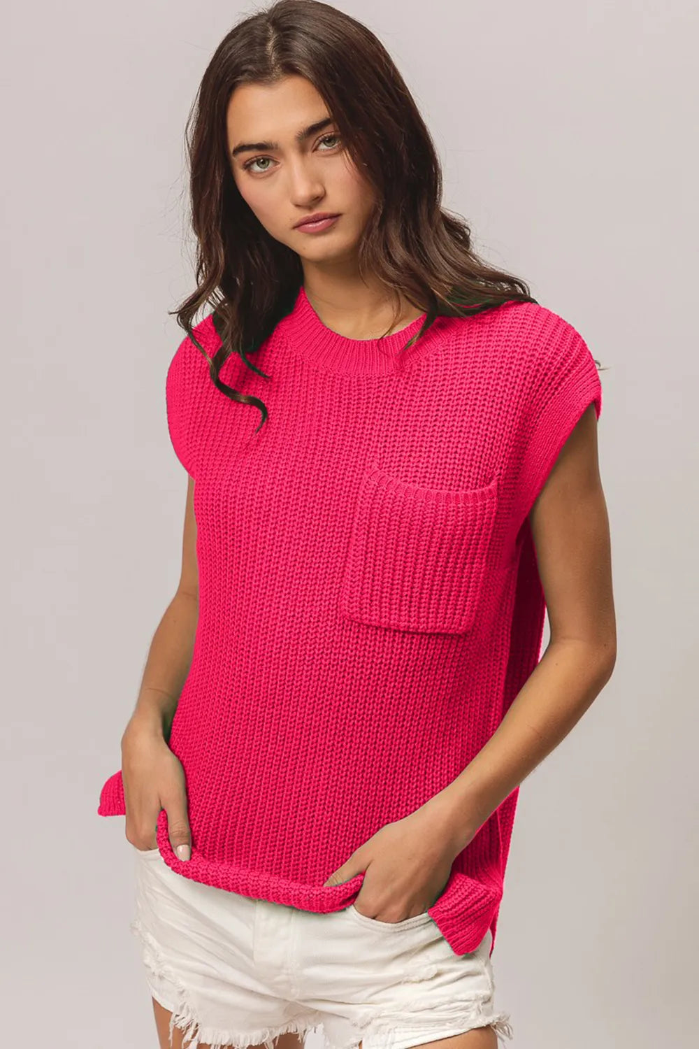 Front view of a fuchsia cap-sleeve knit top with a single chest patch pocket; white shorts are styling only and are not included.
