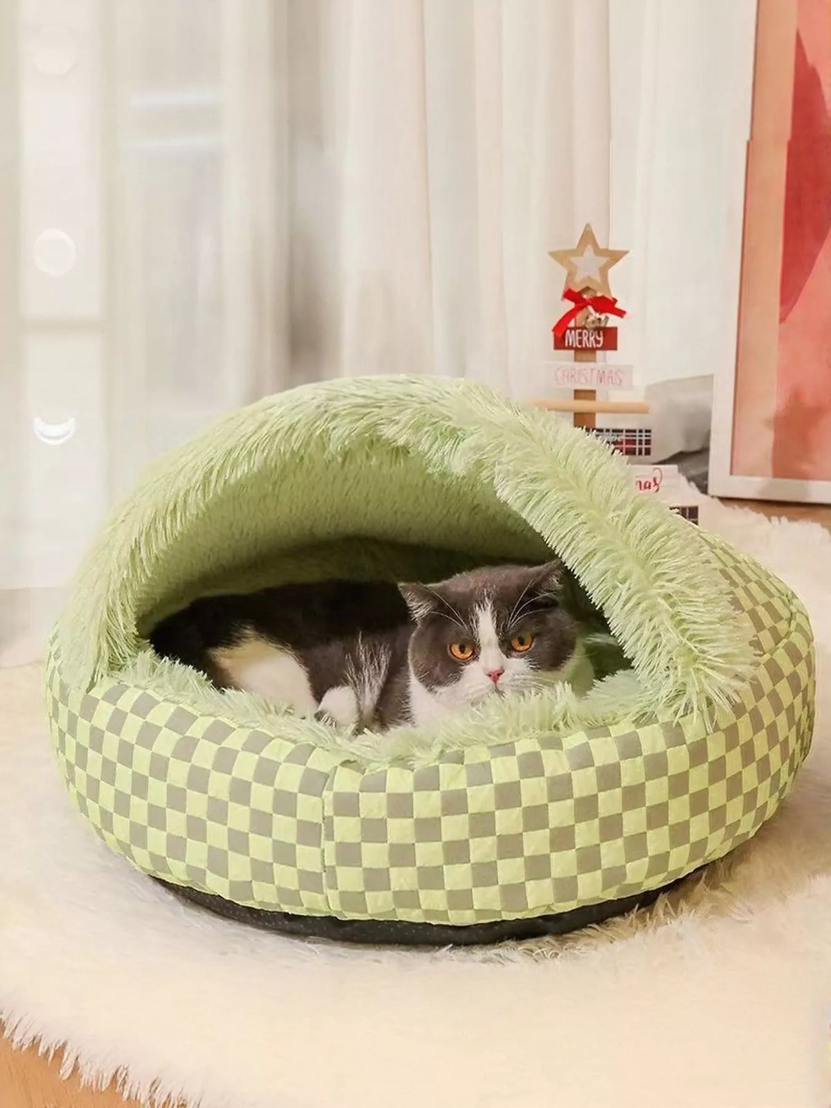 Green checkerboard covered pet nest with a cat resting inside; one nest sold separately.