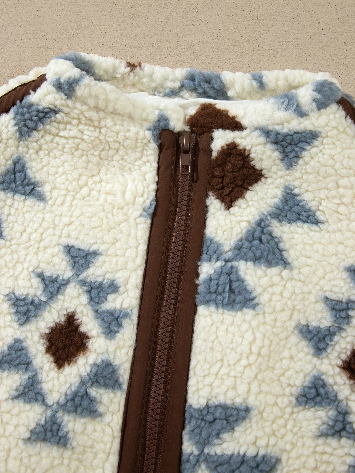 Close-up of the sweatshirt's raised collar, brown zip placket and sherpa texture.