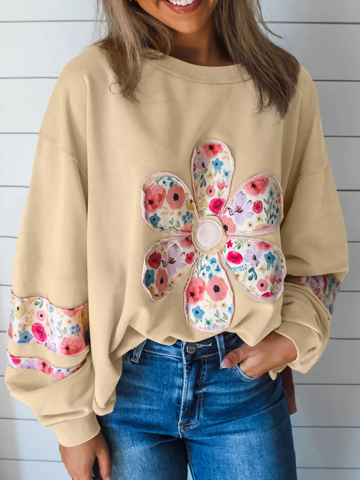 Beige floral applique sweatshirt, front view with round neck and long sleeves. Trousers are styling only.