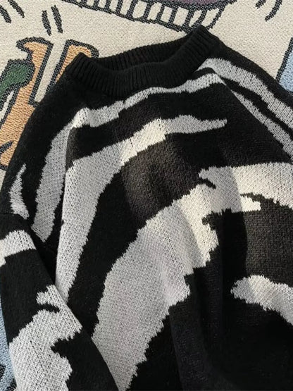 Angled close-up of the black sweater's neckline and light-gray knit pattern.