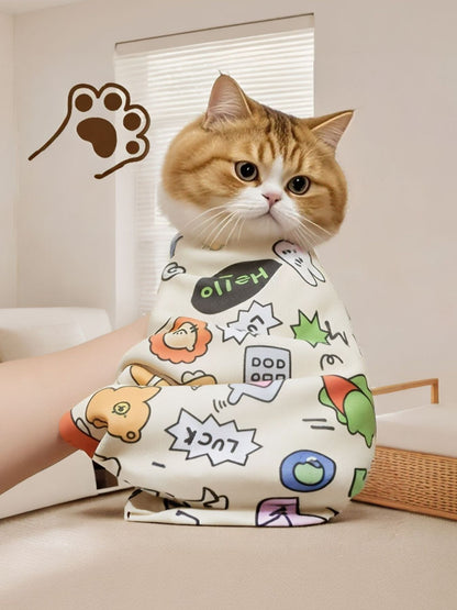 Orange and white cat wrapped in a colorful cartoon-print pet bath towel.