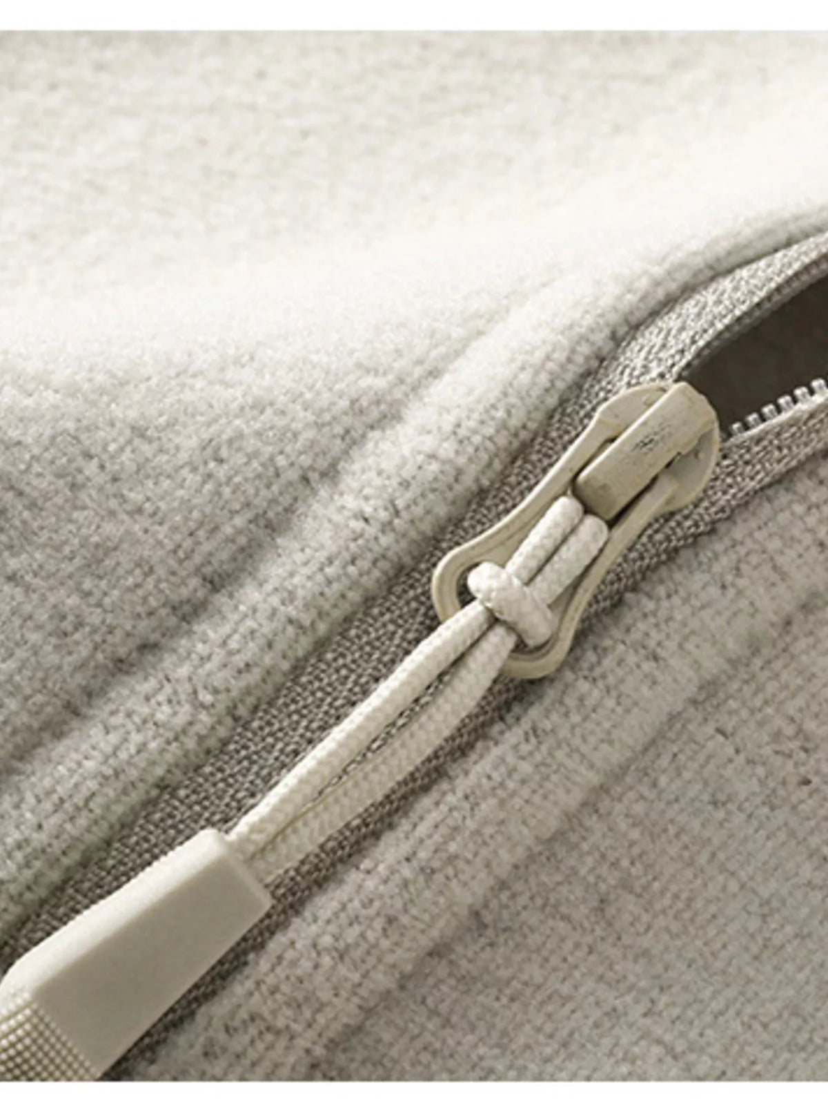 Beige sweatshirt zipper and pull detail