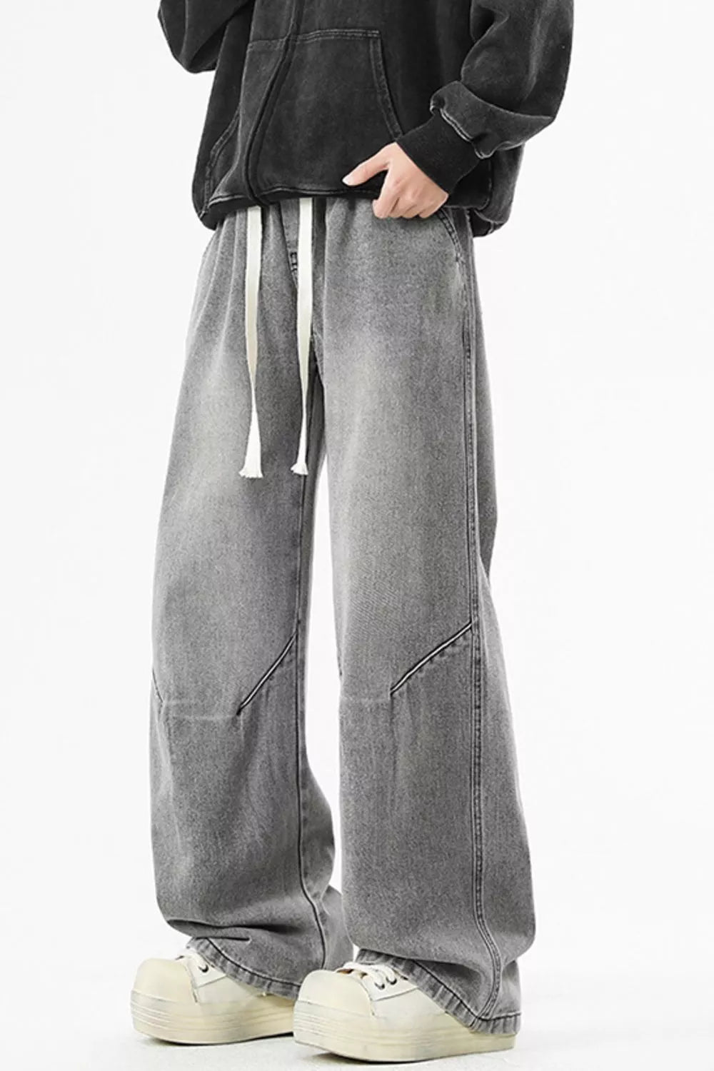 Soot gray men's washed wide-leg jeans with a long cream drawstring, front three-quarter view. One pair of jeans only.