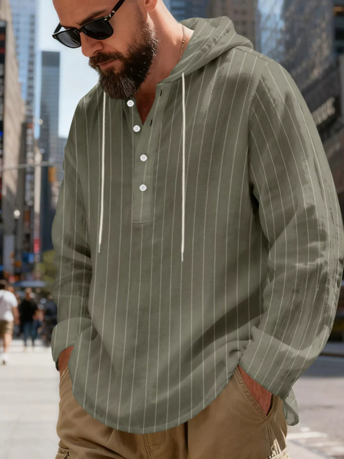 Men's striped Henley hoodie in Army Green — angled front view showing the hood and buttoned neckline; trousers and accessories are styling only.