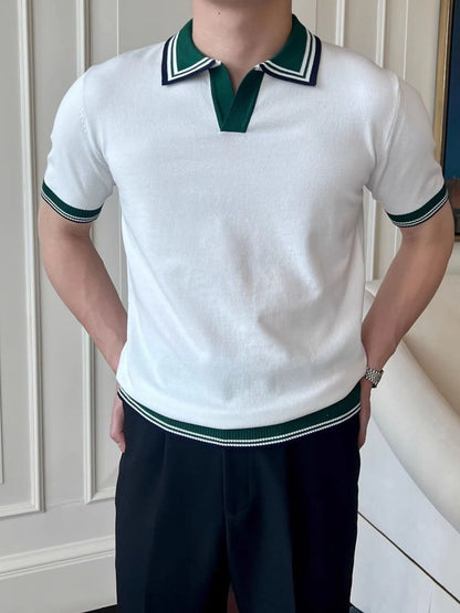 White polo front view with a dark green placket and striped collar and sleeve trim.