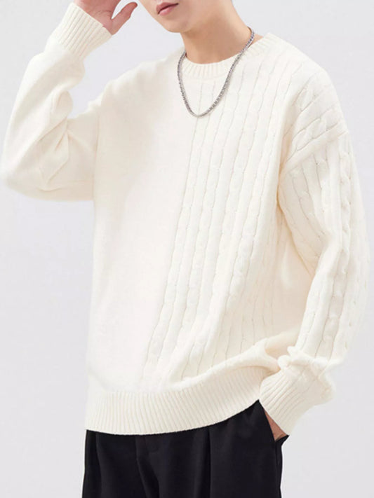 Light apricot crew-neck sweater with an asymmetric cable-knit front panel and long sleeves, angled front view. Sweater only.
