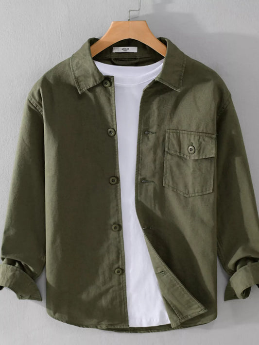 Men's green button-up shirt on a hanger, styled over a white undershirt