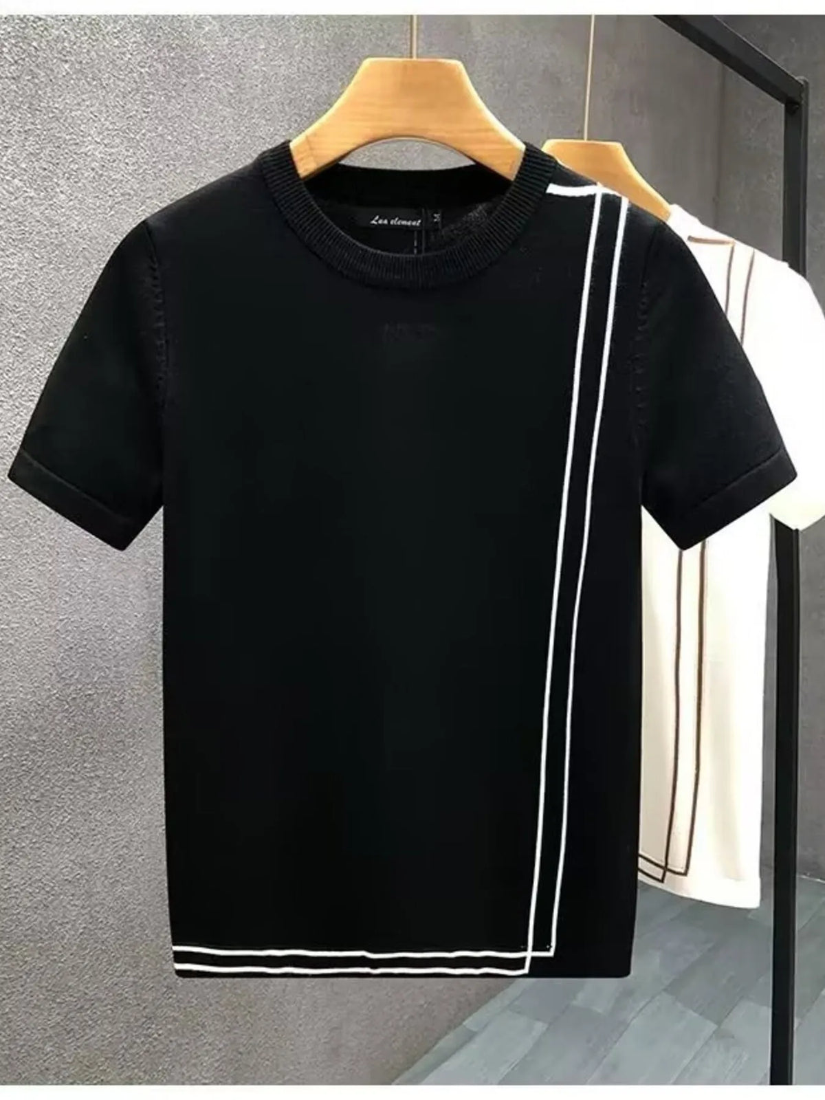 Black contrast-trim T-shirt in front, with White color option behind. One T-shirt per order.